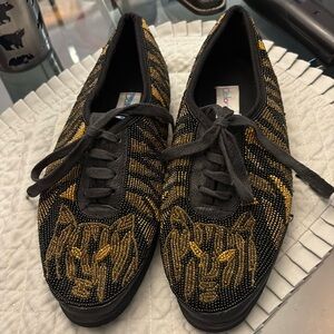 Color werks sequence, black tennis shoes with lion on to size 10 brand new.